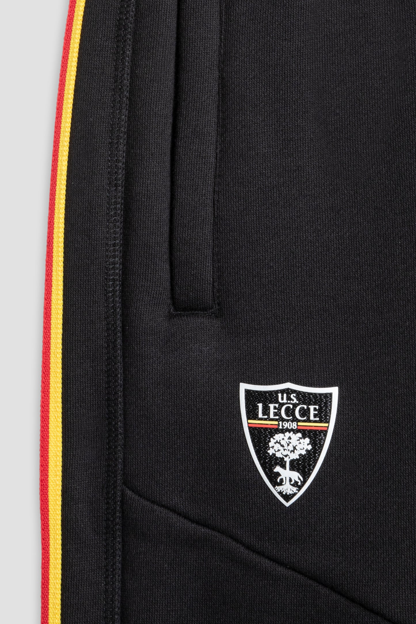 Pantaloni tuta neri con strisce giallo-rosse